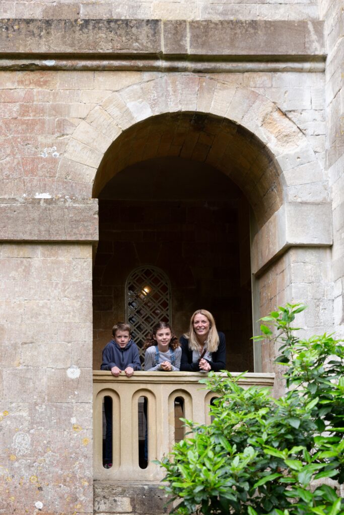 Family lean on balustrade looking outwards from Beckford’s Tower and Museum during a family day out in Bath.