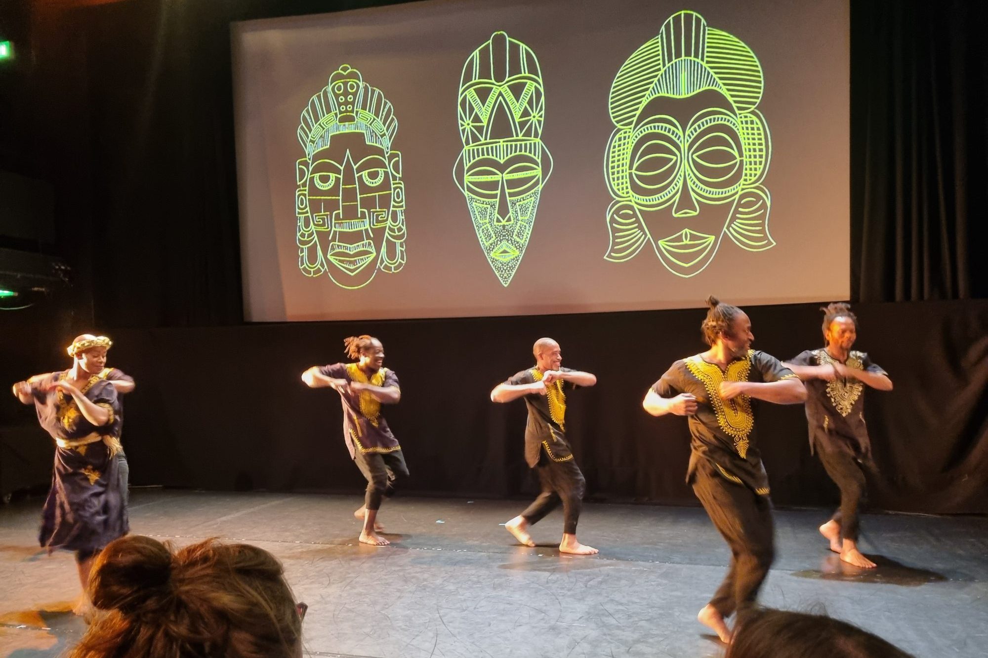 Dancers in front of a mask projection